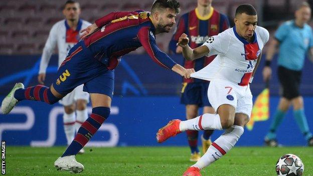 Gerard Pique tugs at Kylian Mbappe's shirt