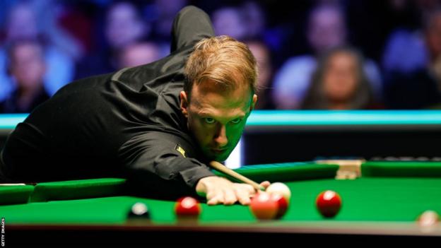 Judd Trump takes a shot at the snooker table