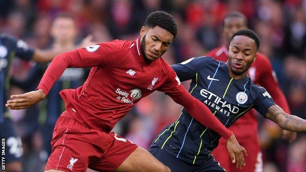 Joe Gomez of Liverpool and Raheem Sterling of Manchester City compete for the ball