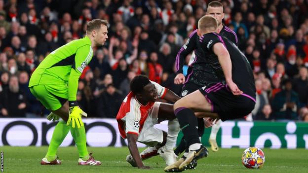 Bukayo Saka ngã xuống sau pha va chạm với Manuel Neuer