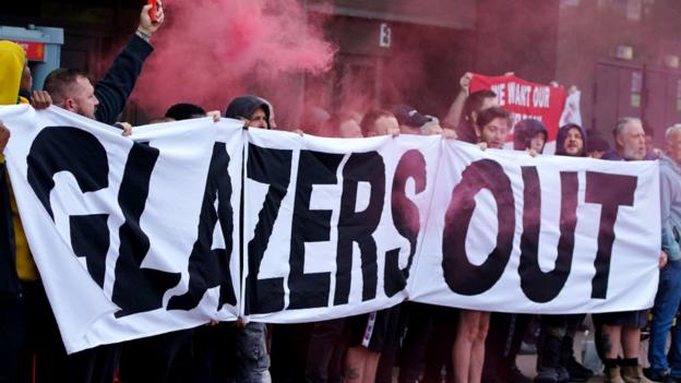 Manchester United fans hold a 'Glazers Out' banner