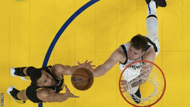 Stephen Curry (left) in action for the Golden State Warriors as he challenges for the ball with the Dallas Mavericks star Luka Doncic