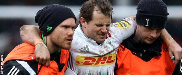 Nick Evans of Harlequins is helped off the pitch