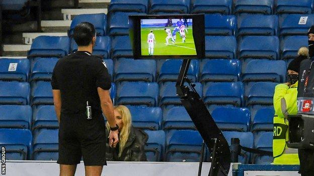 Referee Serdar Gözübüyük reviews the VAR monitor for a potential penalty for a foul on Rangers' Ryan Kent during a UEFA Europa League match between Rangers and Red Star Belgrade at Ibrox