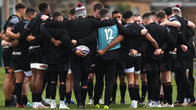 Wales players are arm-in-arm as they gather in a circle at training