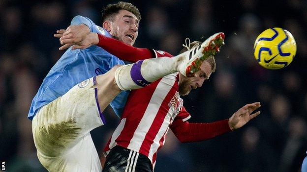 Manchester City defender Aymeric Laporte tussles with Sheffield United's Oliver McBurnie