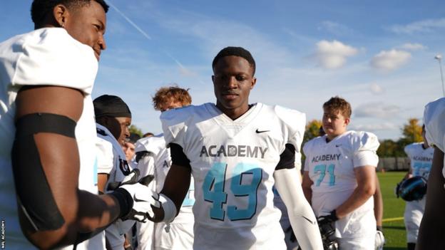 Emmanuel Okoye leaves the field after a game for the NFL Academy