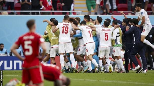 Wales players sink to the turf after Iran's opening goal