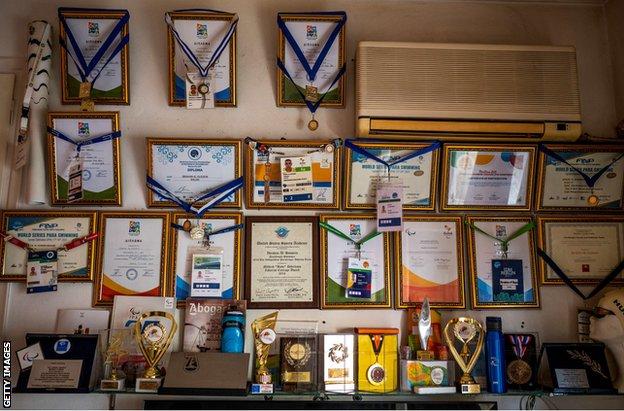 Medals and awards on Al Hussein's wall inside his flat in Athens