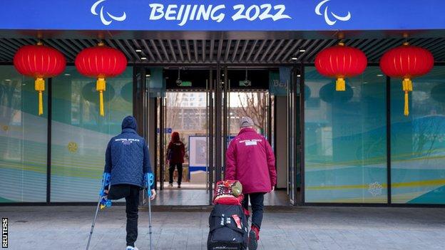 Neutral athletes of the team formerly known as the Russian Paralympic Committee arrive at the Paralympic Village with tape covering the word Russia on their clothing ahead of the Beijing 2022 Winter Paralympic Games