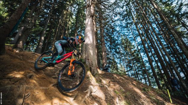 Tahnee Seagrave competing in downhill mountain biking, pictured racing through a forest