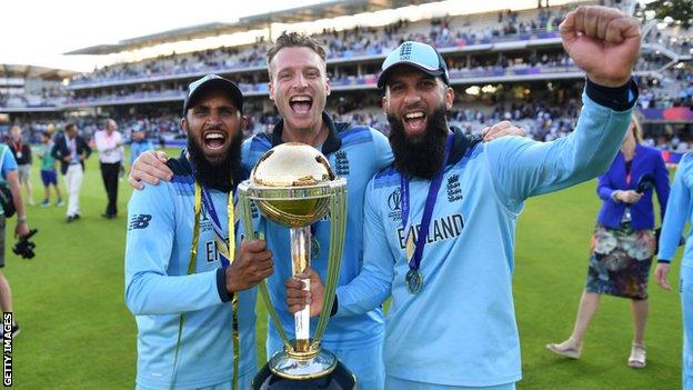 Moeen Ali, Jos Buttler und Adil Rashid feiern mit der Trophäe nach dem Sieg im Finale des ICC Cricket World Cup 2019 zwischen Neuseeland und England auf dem Lord's Cricket Ground