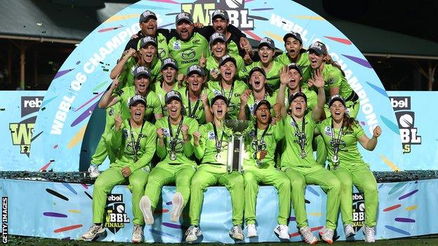 Sydney Thunder players and staff celebrate with the WBBL trophy after beating Melbourne Stars in the final