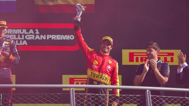 Carlos Sainz holds the third-place winner's trophy