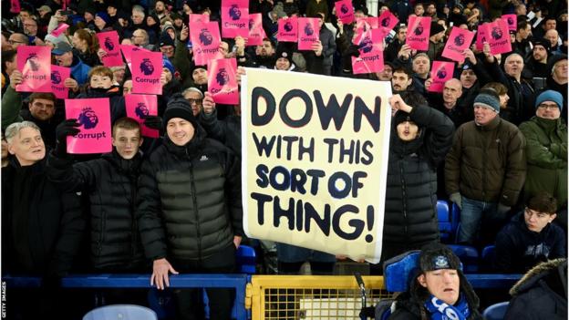 Fans holding up protest cards and banners at Goodison Park