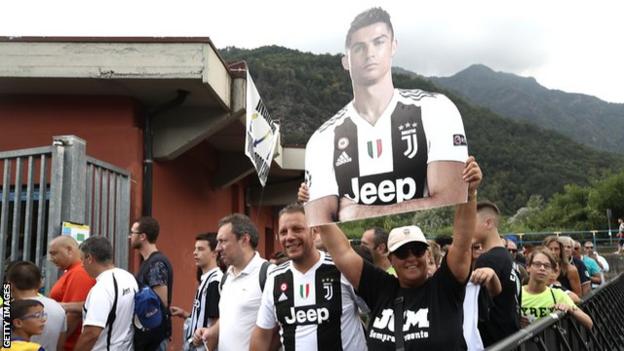 A Juventus supporter holds a cardboard cutout of Cristiano Ronaldo before the friendly got under way
