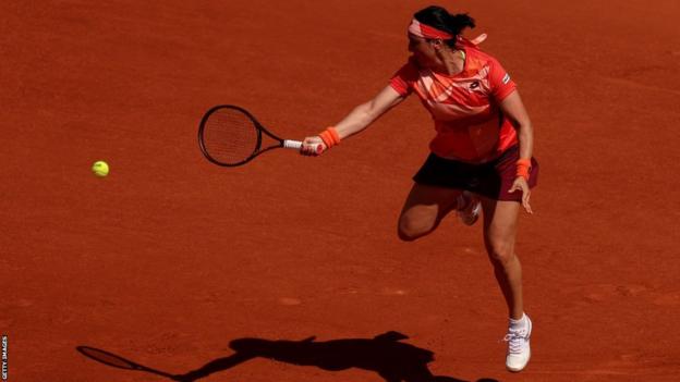 Tunisia's Ons Jabeur leaps to hit a return at the French Open