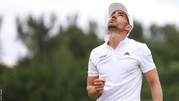 Camilo Villegas looks to the sky and clenches his fist in celebration