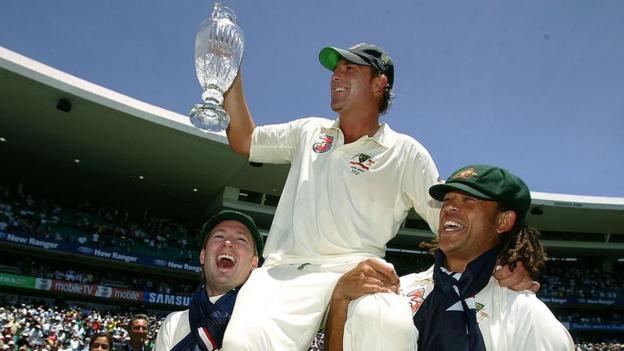 Shane Warne (centre) celebrates on the shoulders of Michael Clarke (left) and Andrew Symonds (right) with the Ashes trophy