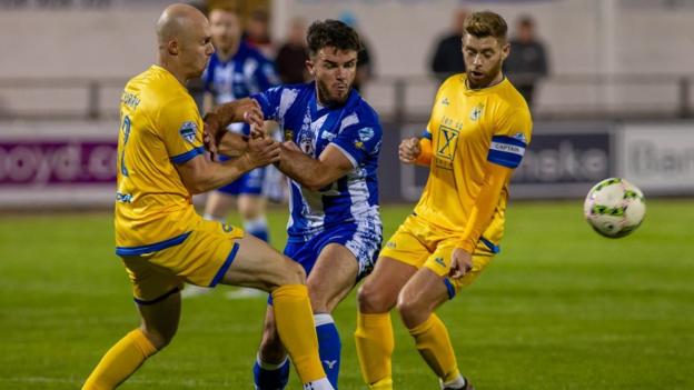Newry City's Philip Donnelly and Dungannon's Dean Curry and James Knowles