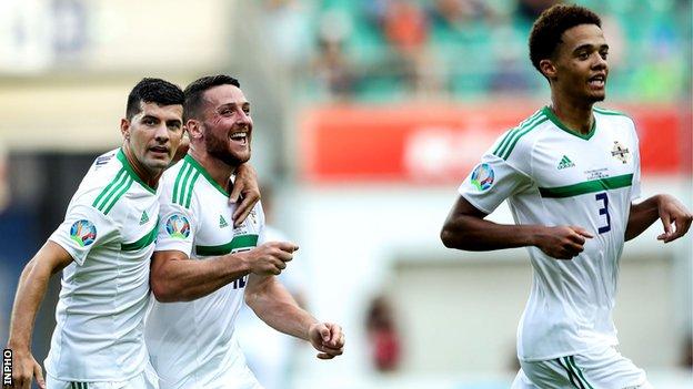 Conor Washington celebrates with Jordan Jones and Jamal Lewis after scoring in Northern Ireland's qualifier win in Estonia in June