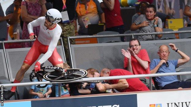 Team England cyclist Matt Walls crashes over the barriers and into the crowd at the velodrome during the Commonwealth Games