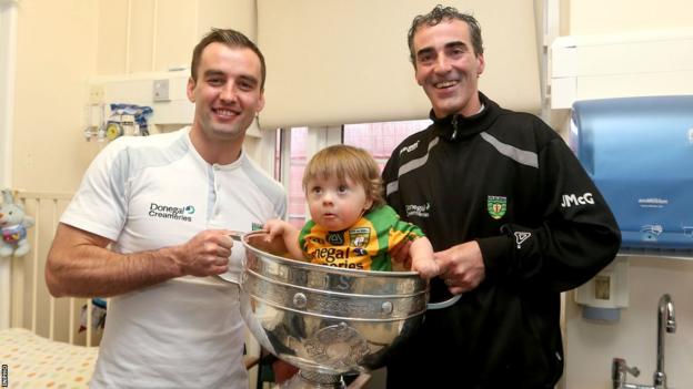 Karl Lacey and Jim McGuiness celebrate the 2012 All-Ireland triumph with young fan Matthew Murray in the Sam Maguire Cup