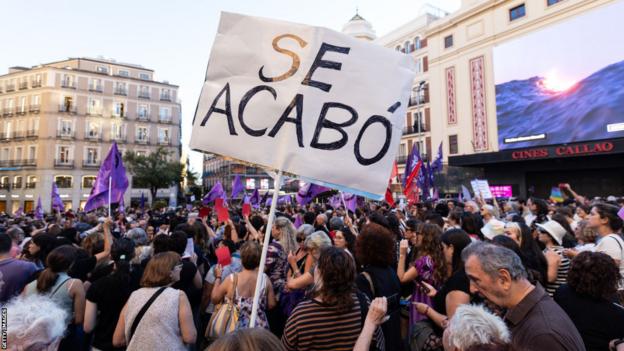 Los manifestantes levantan una pancarta con las palabras: 