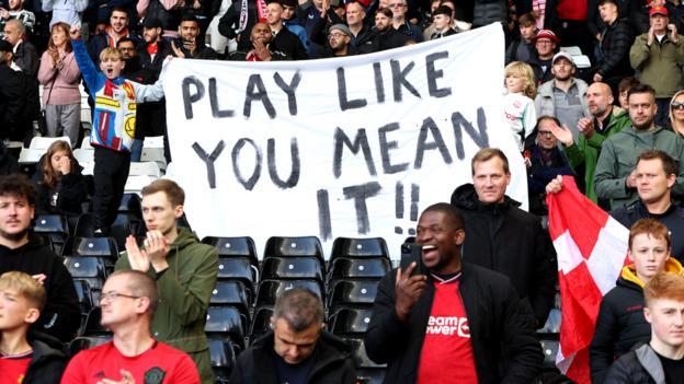 Manchester United fans unveil a banner which read 'Play Like You Mean It' before the match with Fulham