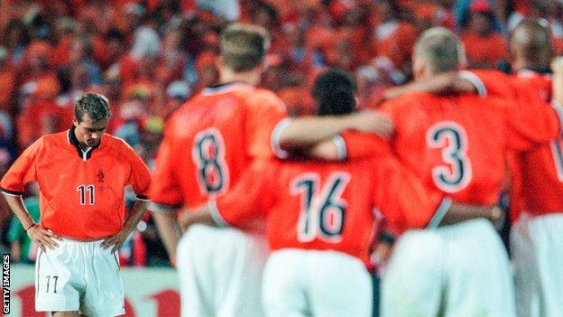 Philip Cocu of the Netherlands walks back to his team after missing the second penalty for the Dutch team in the semi-final shoot-out