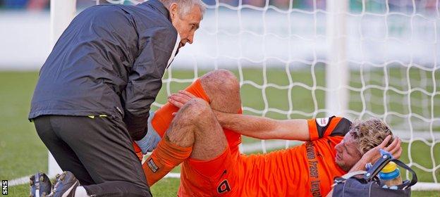 Dundee United's Lewis Toshney receives treatment for an ankle injury at Easter Road