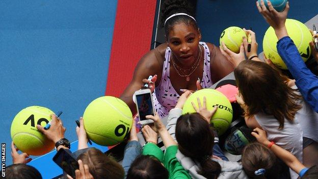 Serena Williams signs giant tennis balls for fans at the Australian Open in January
