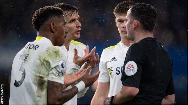 Leeds players protest with referee Chris Kavanagh when he awards Chelsea an injury-time penalty