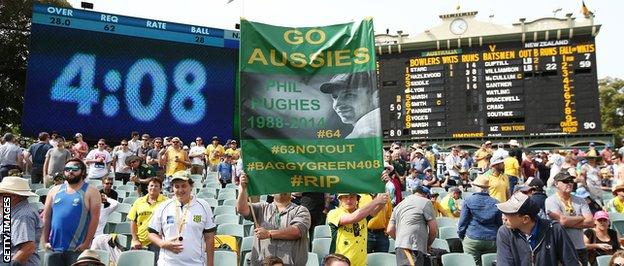 The crowd stand to remember Phillip Hughes
