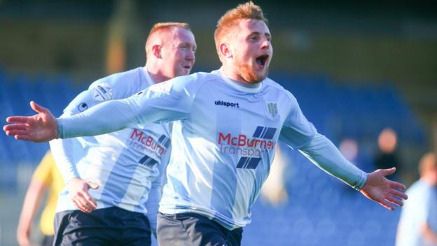 David Cushley runs to celebrate with Ballymena supporters after scoring his side's winner against Dungannon in the final minute