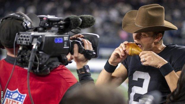 Daniel Carlson eating a turkey leg after the Las Vegas Raiders won their Thanksgiving game in 2021