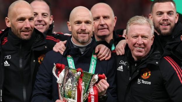 Manchester United manager Erik ten Hag (centre) holds the EFL Cup trophy