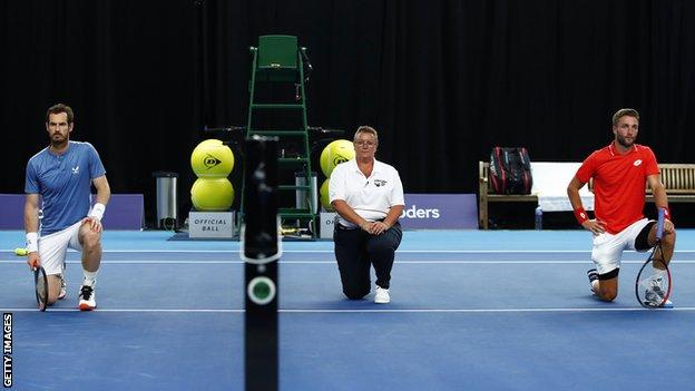 Andy Murray, el árbitro Alison Hughes y Liam Broady se arrodillan antes del partido