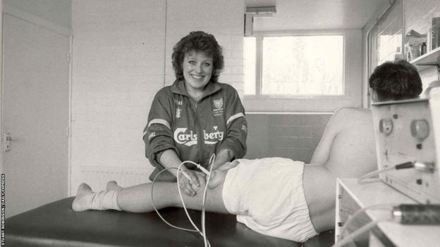 Caroline Brouwer using an interferential machine on an injured player in Wimbledon's dressing room