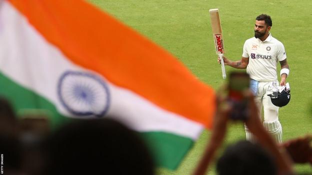 El indio Virat Kohli celebra su siglo contra Australia frente a la celebración de los aficionados locales