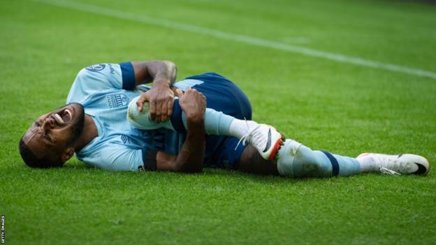 Brentford defender Rico Henry reacts to injuring his knee against Newcastle