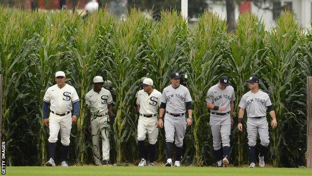 Field of Dreams - White Sox and Yankees players walk out from cornfields in Iowa