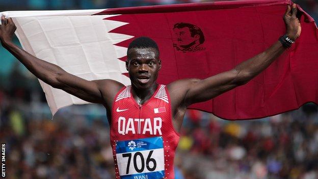 Abdalelah Haroun hold aloft a Qatari flag