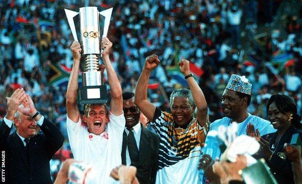 Neil Tovey celebrates by lifting the Afcon trophy of 1996 alongside Nelson Mandela