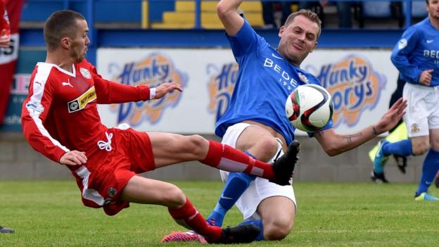 Cliftonville winger Martin Donnelly slides in to challenge Ciaran Caldwell in the Mournview Park clash against Glenavon