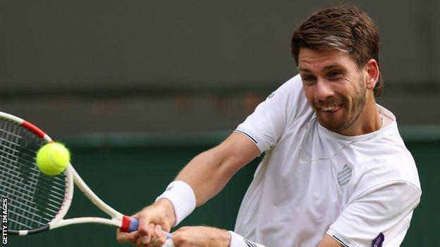 Cameron Norrie returns a ball against Tommy Paul in their Wimbledon fourth-round match