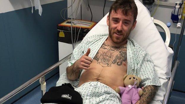 Lee Johnston gives the thumbs up as he is treated in hospital following Sunday's crash