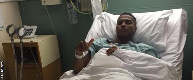 Manchester United player Antonio Valencia gives the thumbs up from his hospital bed