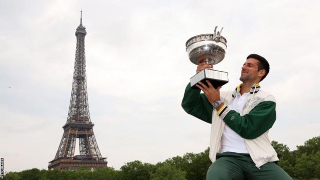 Novak Djokovic celebrates with the French Open trophy aft  his triumph  astatine  Roland Garros past  month