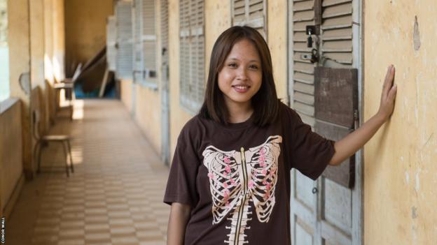 Sovann ThidaAva poses for a portrait in a cloistered walkway